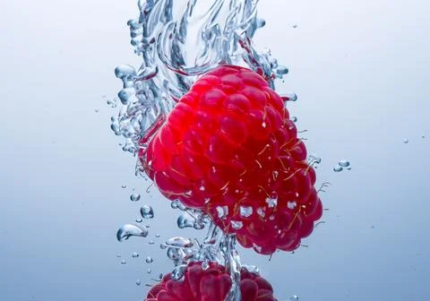Raspberry splash in water Stock Photos
