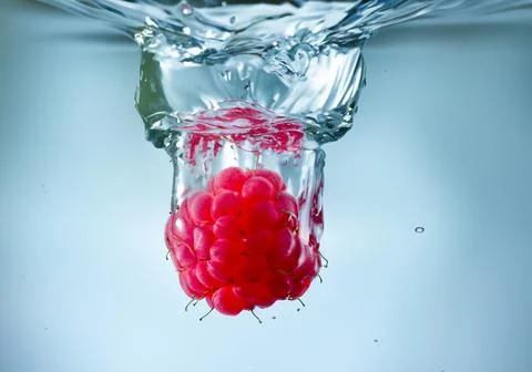Raspberry splash in water Stock Photos