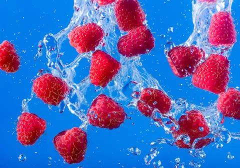 Raspberry splash in water Stock Photos