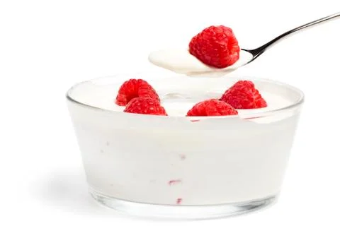 Raspberry on a spoon over a dessert with raspberries Stock Photos