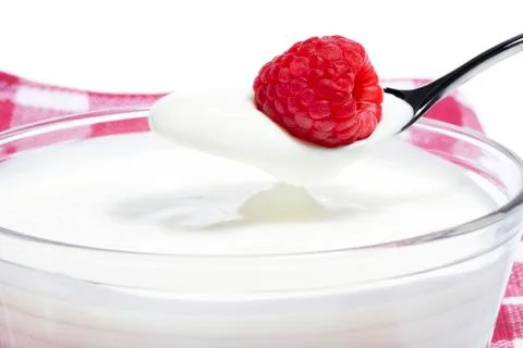Raspberry on a spoon with yogurt Stock Photos