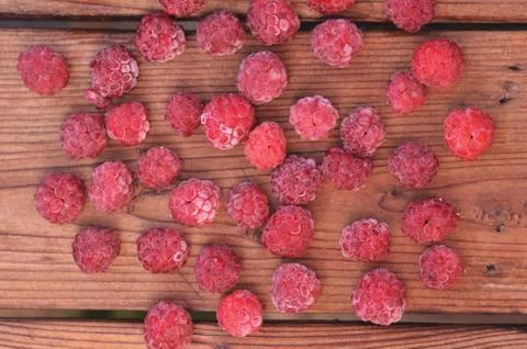 Raspberry is spread out on a wooden background Stock Photos