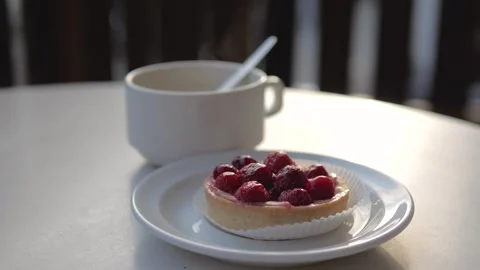 Raspberry tart and hot coffee in a cafe during a sweet break Stock Footage 320416527
