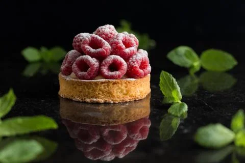 Raspberry tart dessert on dark background. Traditional french sweet pastry Stock Photos