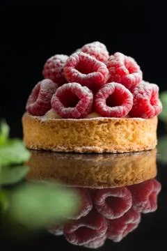 Raspberry tart dessert on dark background. Traditional french sweet pastry Foto stock