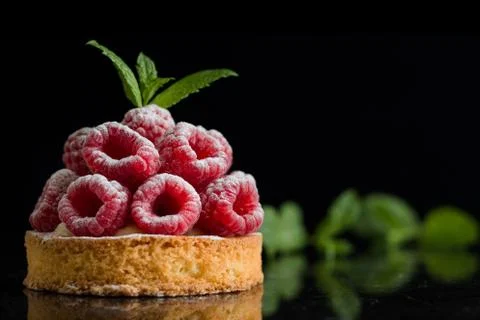 Raspberry tart dessert on dark background. Traditional french sweet pastry Stock Photos