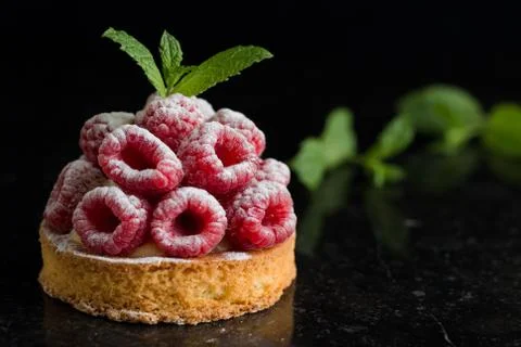 Raspberry tart dessert on dark background. Traditional french sweet pastry Stock Photos