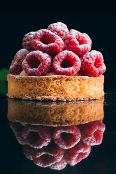 Raspberry tart dessert on dark background. Traditional french sweet pastry Stock Photos