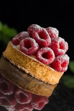 Raspberry tart dessert on dark background. Traditional french sweet pastry Stock Photos