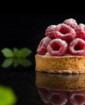 Raspberry tart dessert on dark background. Traditional french sweet pastry Stock Photos