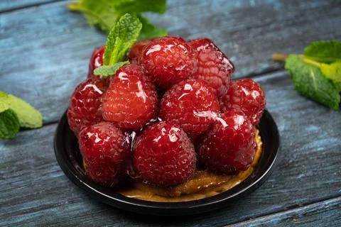 Raspberry tartlet on a gray background with mint Stock-Fotos