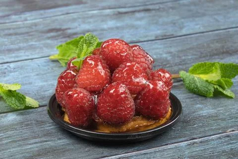 Raspberry tartlet on a gray background with mint Stock Photos