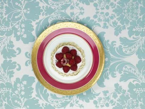 Raspberry tartlet in plate against patterned background Stock Photos