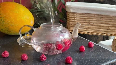 Raspberry tea with rose Hand preparing fresh flower tea in elegant glass teapot Stock Footage 317710240