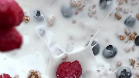 Raspberry throwing splashing yoghurt top view. Calcium oat liquid with berries Stock Photos