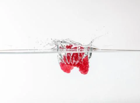 Raspberry in water on a white background with water sprays around, can be used Foto stock