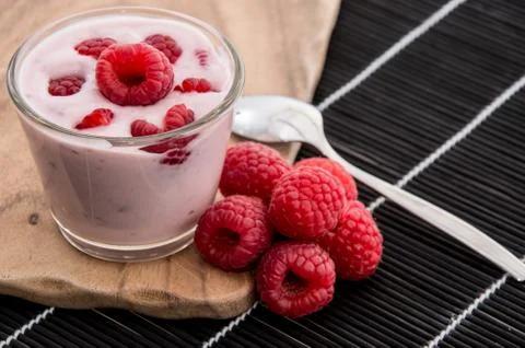 Raspberry yogurt on black background Stock Photos