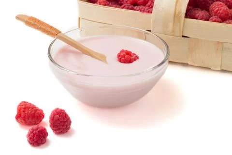 Raspberry yogurt in a glass cup with raspberry basket on a white background Stock Photos
