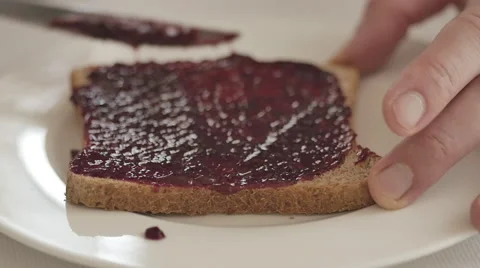 Rasperry jam spread on toasted bread 4 Stock Footage 50616388