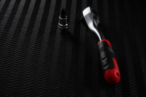 Ratchet wrench with socket attachment on dark textured background Stock Photos