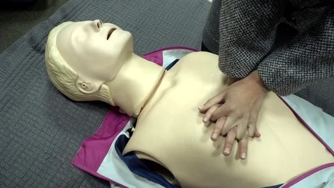 Rates of first aid from the Red Cross - chest compressions On A Mannequin Stock Footage 70563587
