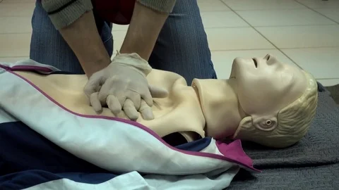 Rates of first aid from the Red Cross - chest compressions On A Mannequin Stock Footage 70563589
