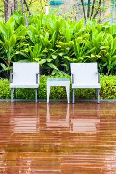 Rattan chairs and table in empty garden Stock Photos