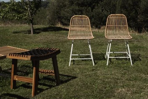 Rattan chairs stand on grassy field Foto stock
