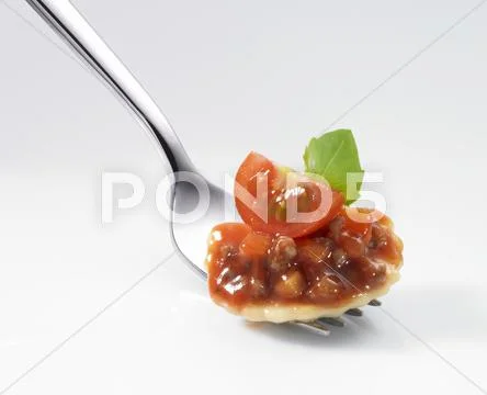 Ravioli filled with tomatoes and minced meat with sauce and a basil leaf on a Stock Photos