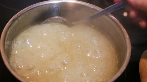 Raw agar-agar is cooked in a pot on the stove. Syrup liquid, raw, lots of air bu Stock Footage 85037253