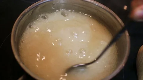 Raw agar-agar is cooked in a pot on the stove. The liquid is not ready, thick fo Stock Footage 85037297