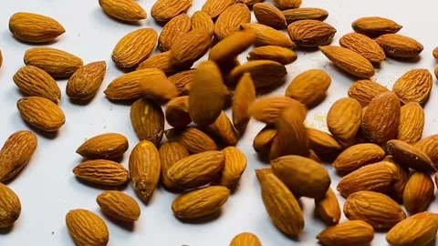 Raw almond nuts falling in slow motion on white background Stock Footage 336471532