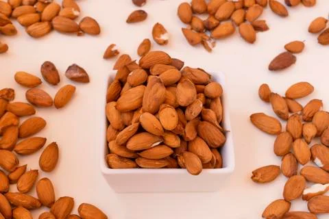 Raw almonds on a white plate. Stock Photos