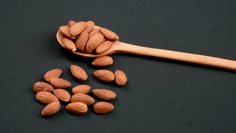 Raw Almonds On Wooden Spoon Rotating On Black 4K Видео 332844997
