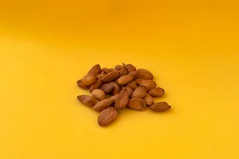 Raw almonds on a yellow background. Stock Photos
