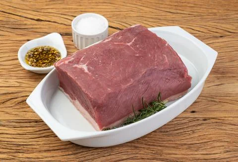Raw ancho beef, typical argentinian cut, over white plate with seasonings Stock Photos