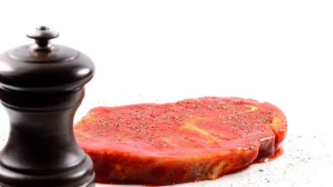 Raw and marinated pork neck on a turn table with pepper mill Stock Footage 124525809