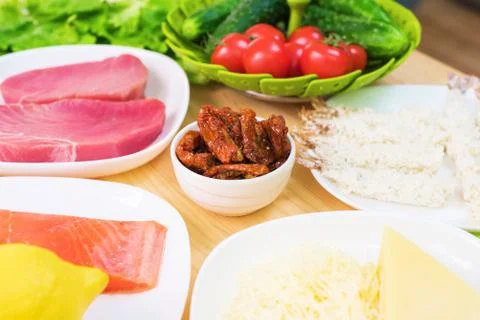 Raw appetizing fillet of tuna on a table with a yard of Greek salad with salmon Stock Photos
