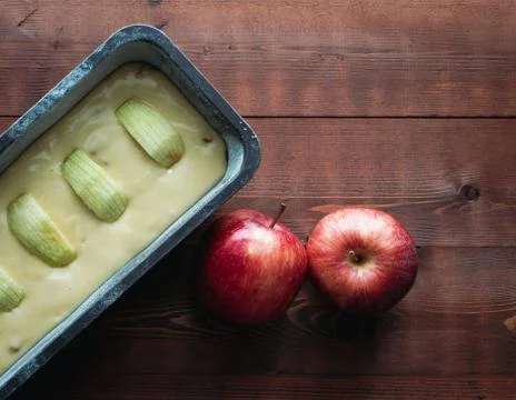 Raw apple cake before baking on a dark wooden base with apple decorations. Co Stock Photos