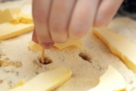Raw apple pie being prepared, showcasing the process of poking holes in the c Stock Photos