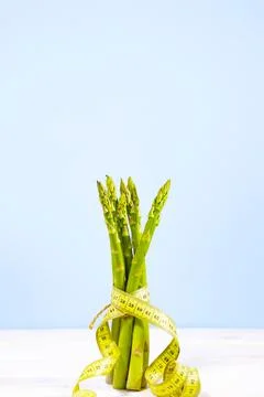 Raw asparagus and measuring type isolated on a blue background, Copy Space Stock Photos