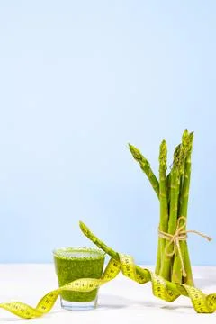 Raw asparagus with measuring type and green fresh smothie isolated Stock Photos