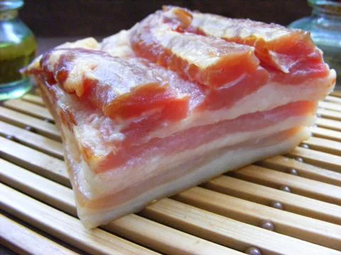 Raw bacon on bamboo Stock Photos