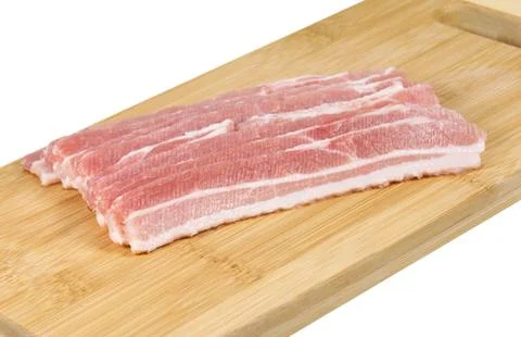 Raw bacon on the board. Stock Photos