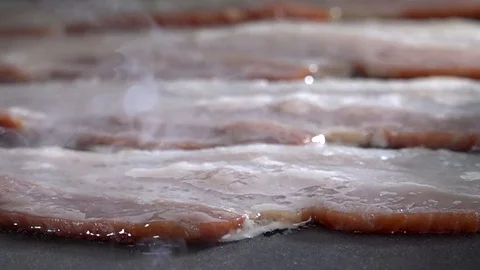 Raw Bacon on the Griddle In Slow Motion Stock Footage 124159157