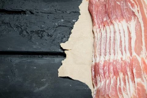 Raw bacon on paper. Stock Photos
