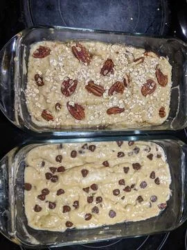 Raw Banana Bread Batter in Two Dishes with Toppings Ready to be Baked Foto stock