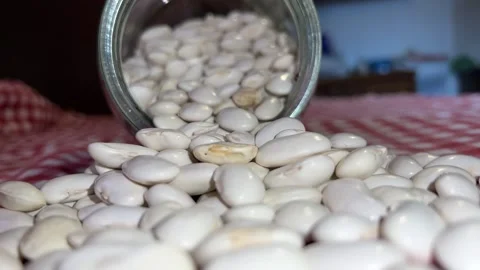 Raw beans come out of the overturned jar on the table Stock Footage 223511073