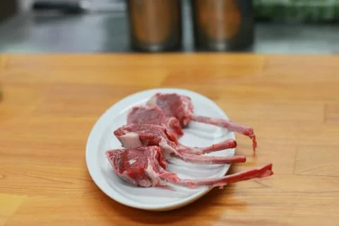 Raw beef bone rib-eye steak on a plate and wooden table. Stock Photos
