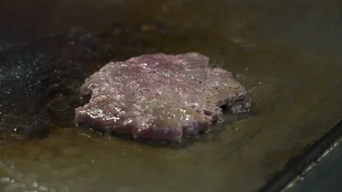 Raw Beef Burger Patty Sizzling on Flat Top Grill Stock Footage 340042723